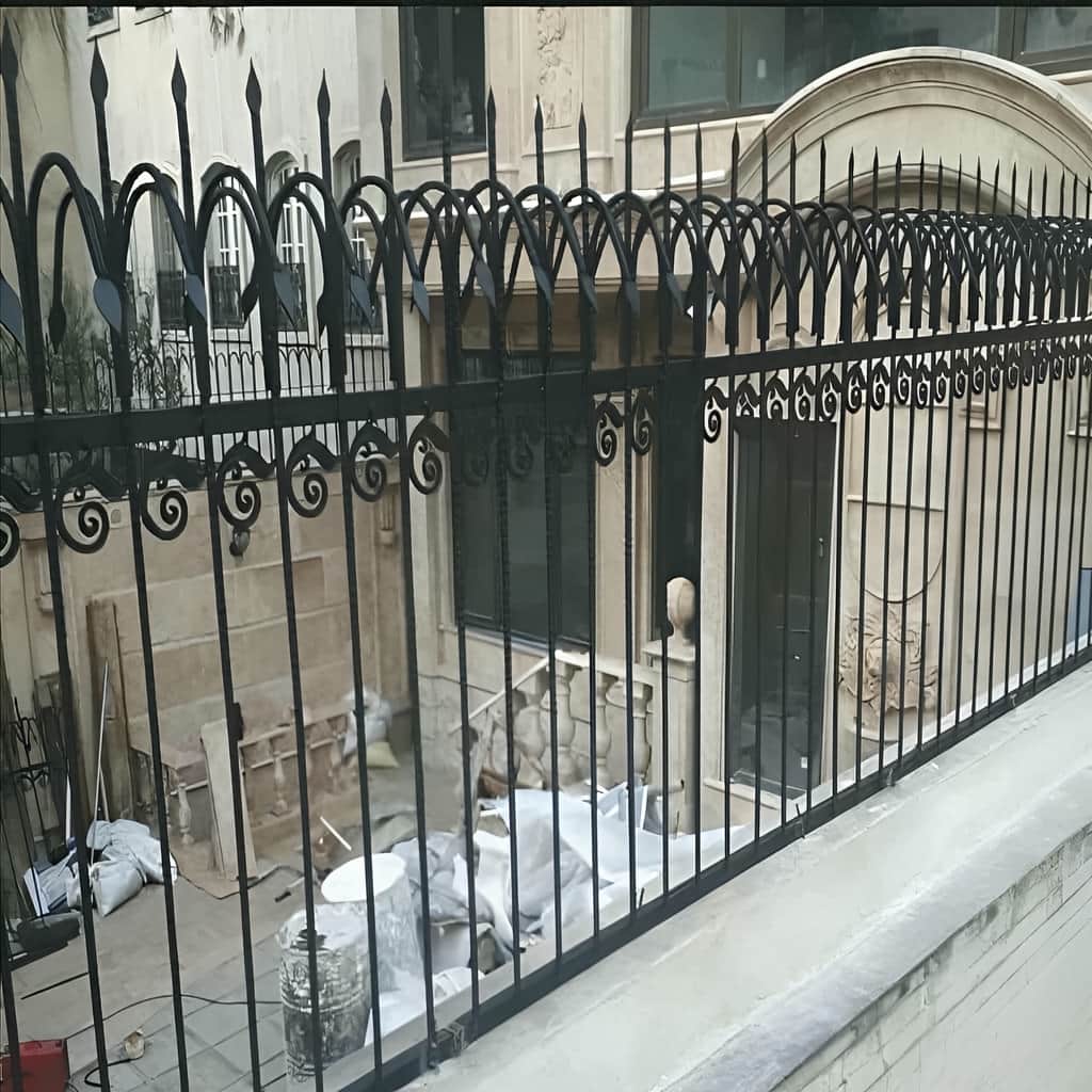 نصب حفاظ سرنیزه ای روی دیوار سنگی حیاط